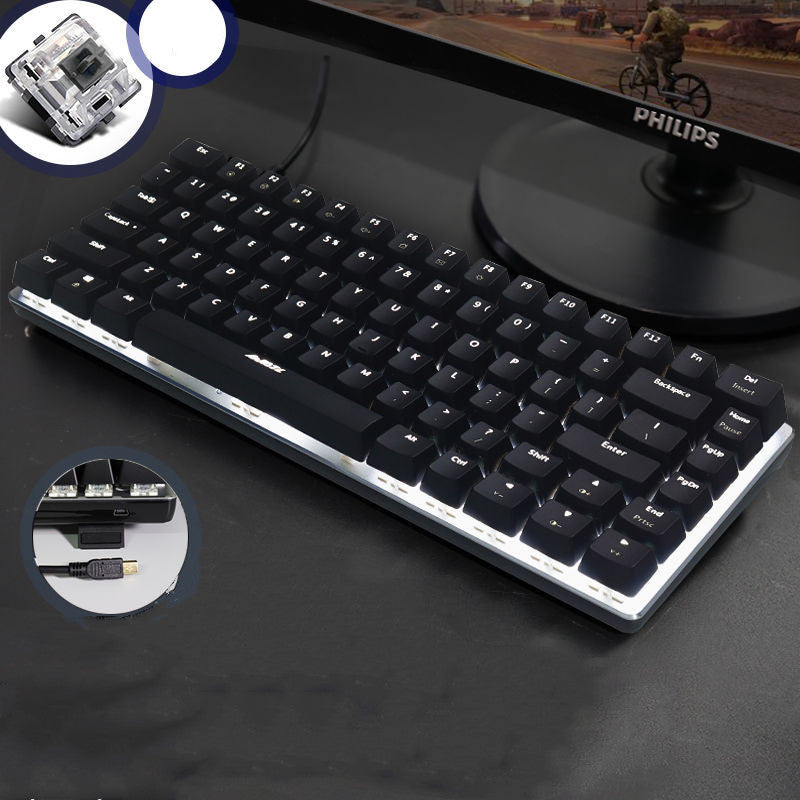 Black keyboard on a dark surface with Philips lamp in the background